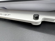Close-up of a vehicle bumper with a hex bolt on a gray surface