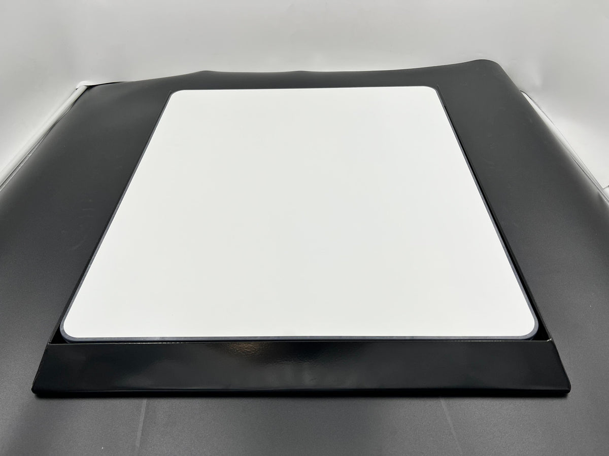 Black car hood with a white square patch on a gray background